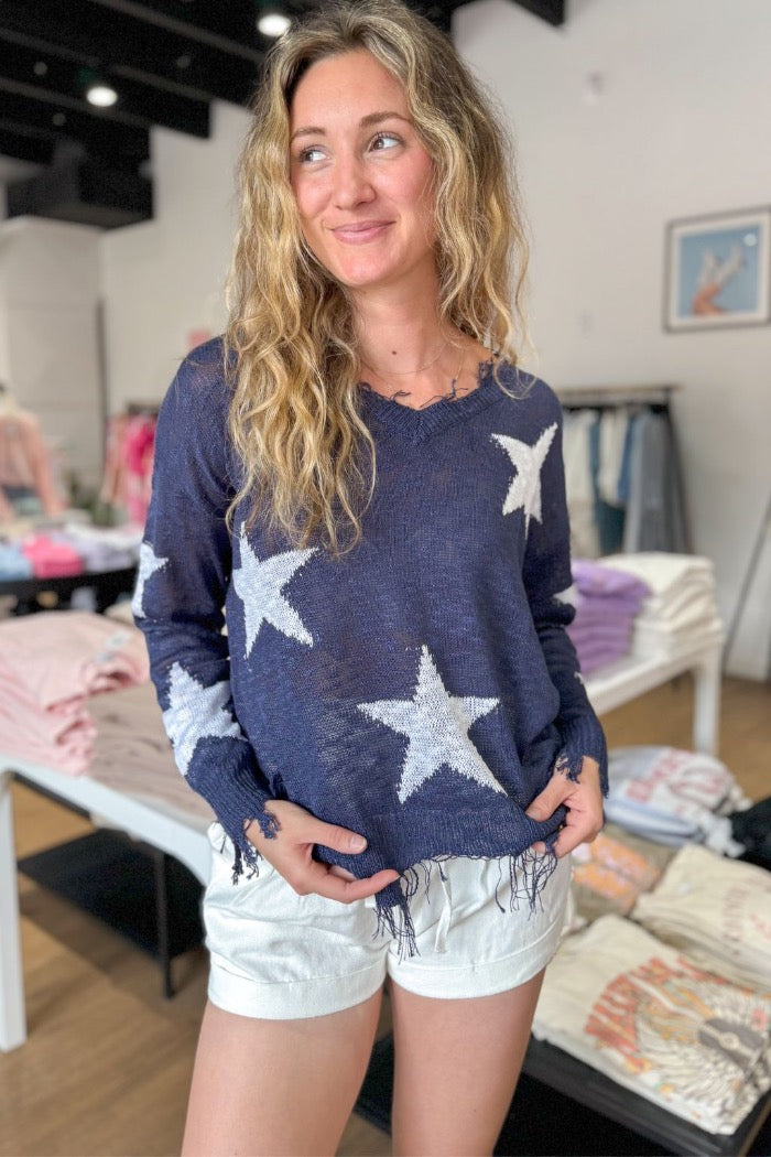 navy frayed hem lightweight sweater with white star pattern on the front and sleeves with a v-neckline