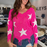 hot pink v-neck long sleeve sweater with frayed hem details and white star print on front and sleeves