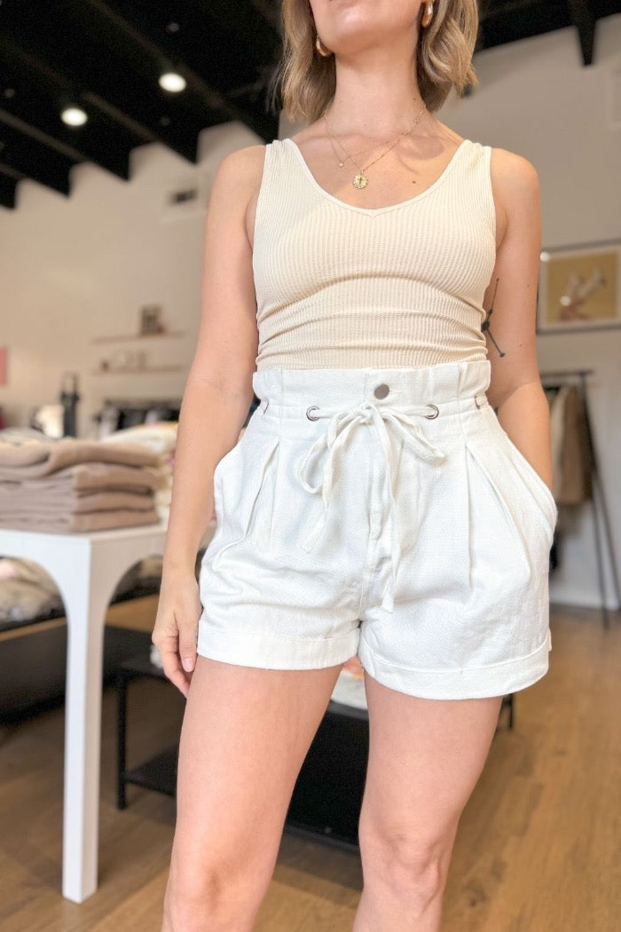 white paperbag style pleated front shorts with tie waist detail, front pockets, zipper fly and button closure