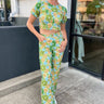 blue, green, and orange floral denim pants with straight leg, front pockets, and zipper fly and button closure, paired with matching crop top